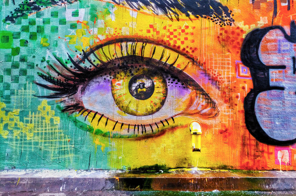 Foto von einem Graffito, auf dem ein buntes Auge zu sehen ist.