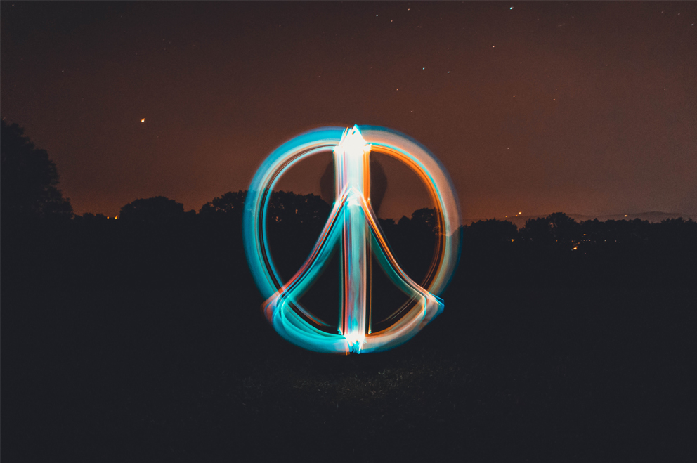 Peace-Zeichen als Lichtspur in die Luft gemalt.