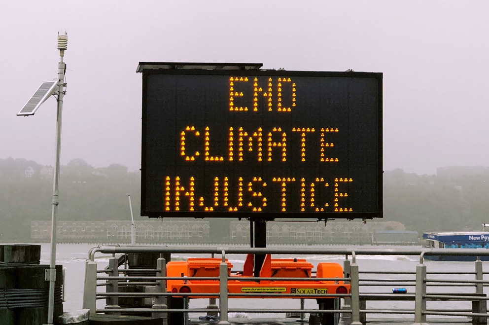 Elektronisches Straßenschild mit der Anzeige "End Climate Justice!"