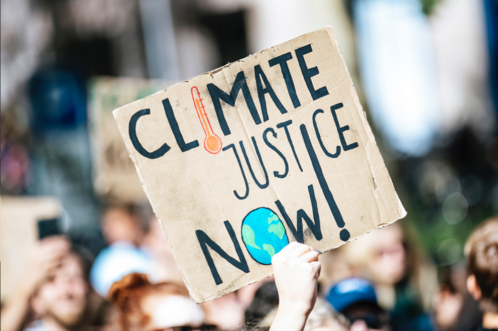 Plakat auf einer Demo. Aufschrift: Climate Justice Now!