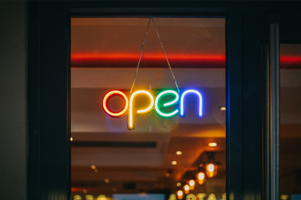 Neon-Schriftzug "open" an einer Tür.