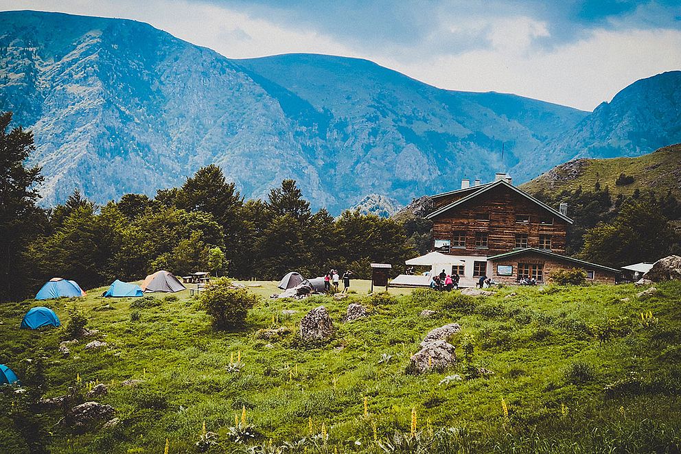 Zelte neben Hütte in den Bergen