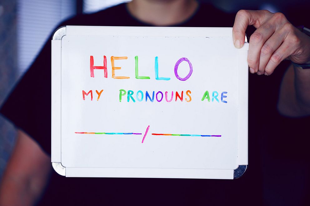 Schild in Regenbogenfarben mit Aufschrift: Hello, my pronouns are …